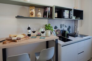 A modern kitchen with a wooden countertop, wine bottles, a coffee machine, and a sink. - DomuS Miniato (San Miniato)