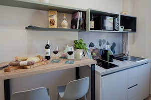 Una cocina moderna con encimera de madera, botellas de vino, una cafetera y un fregadero.