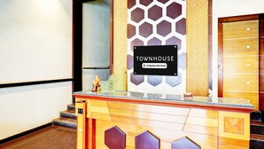 Una mesa de recepción con un letrero que indica 'TOWNHOUSE' y 'Servicio de Empresa'.