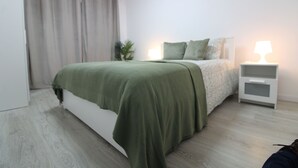 Una camera da letto moderna con un letto, comodini e un tavolino di servizio.
