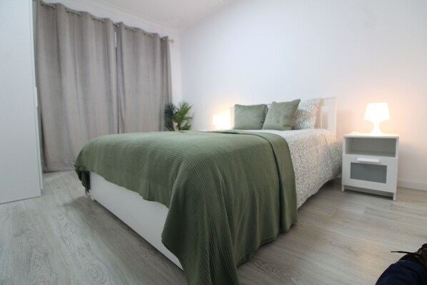Une chambre à coucher moderne avec un lit, des tables de chevet et une commode.