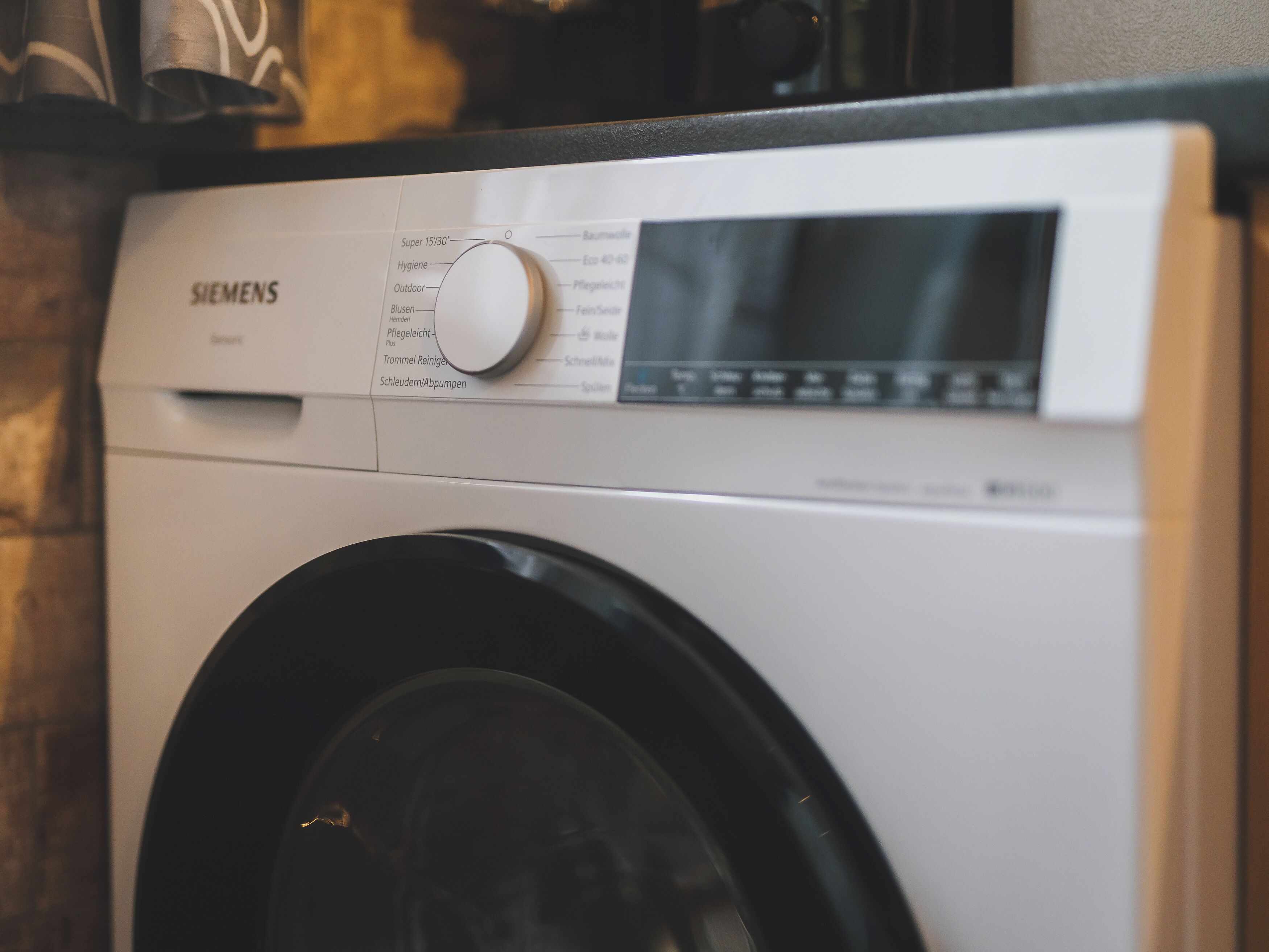 Vue de face d’un lave-linge Siemens, dont le panneau de commande affiche différents réglages.