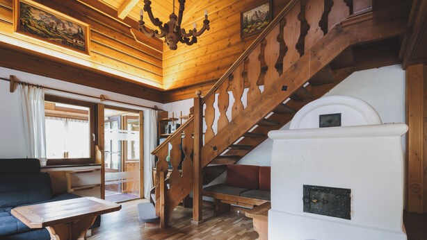 Un intérieur en bois avec un escalier, une cheminée et un canapé.