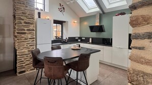 Una cucina moderna con isola centrale, pareti in pietra e lucernari.