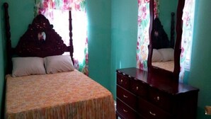 Un dormitorio con cama, cómoda y espejo.