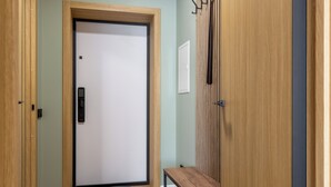 A hallway with a wooden door, a bench, and a coat rack. - Apart in the historical center of Minsk (Minsk)