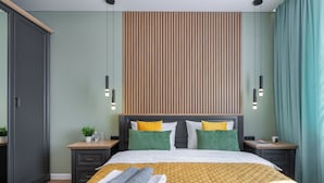 A modern hotel room with a bed, nightstands, a wardrobe, and a view of the city. - Apart in the historical center of Minsk (Minsk)