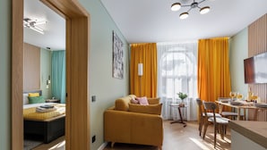 A modern hotel room with a bed, sofa, dining area, and a TV. - Apart in the historical center of Minsk (Minsk)
