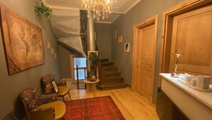 A staircase leading to a second floor, a wooden door, a reception desk, a patterned rug, and a globe artwork. - Roza Mitra Butik Otel (İstanbul)