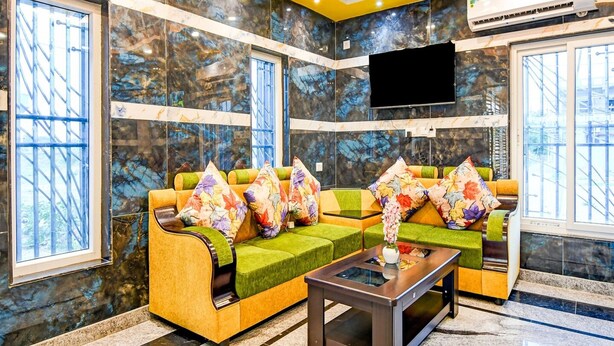 A modern lobby with a sofa set, a coffee table, and a flat-screen TV mounted on the wall. - Deluxe Dholpanda Near Puri Lighthouse (Puri)
