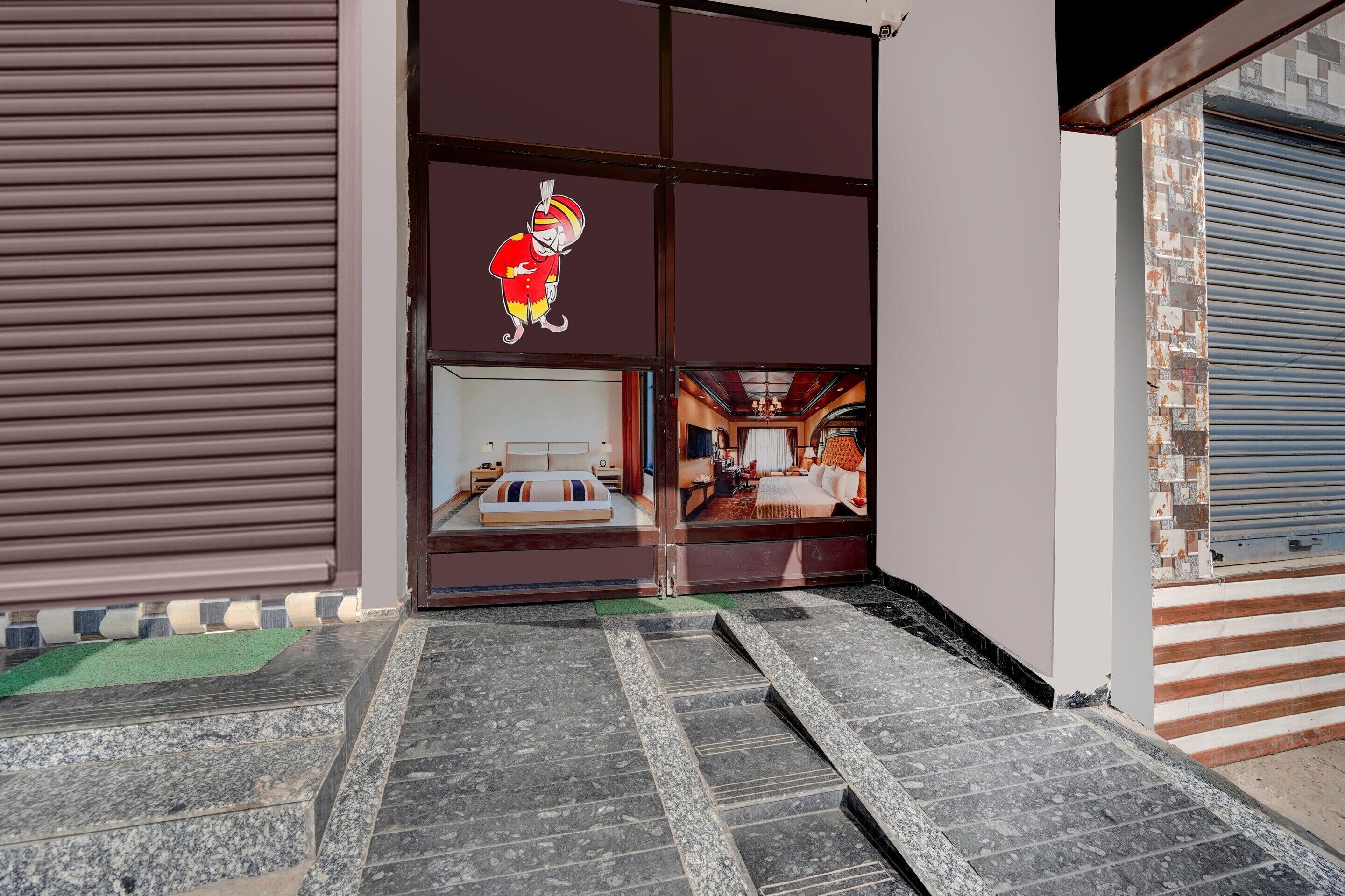 A hotel entrance with a closed shutter, a cartoon character decoration, and a view into the interior.
