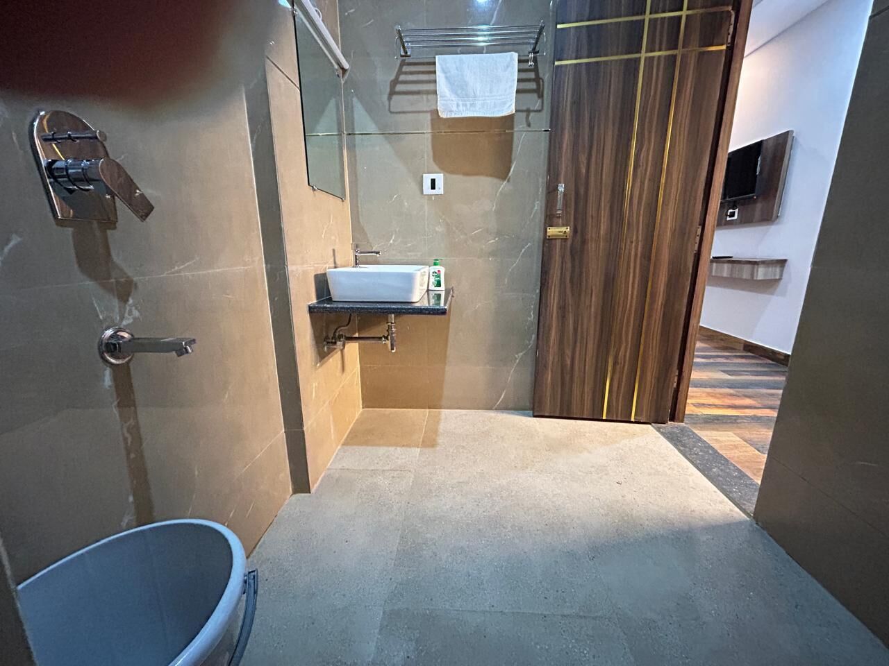 Une salle de bain équipée d’un lavabo, d’un miroir, d’un porte-serviettes et d’un espace douche.