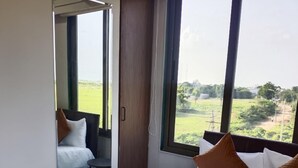 Une chambre d’hôtel avec un lit, une petite table et une vue sur l’extérieur.
