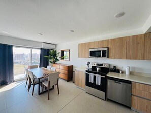 Een moderne keuken met houten kastjes, een ingebouwde magnetron, een fornuis en een vaatwasser.