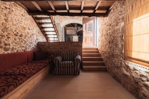 A narrow stone-walled corridor with a wooden staircase, a bench, and a striped chair. - Vertigo Stone Villa - Roumeli Private Pool Escape (Mylopotamos)