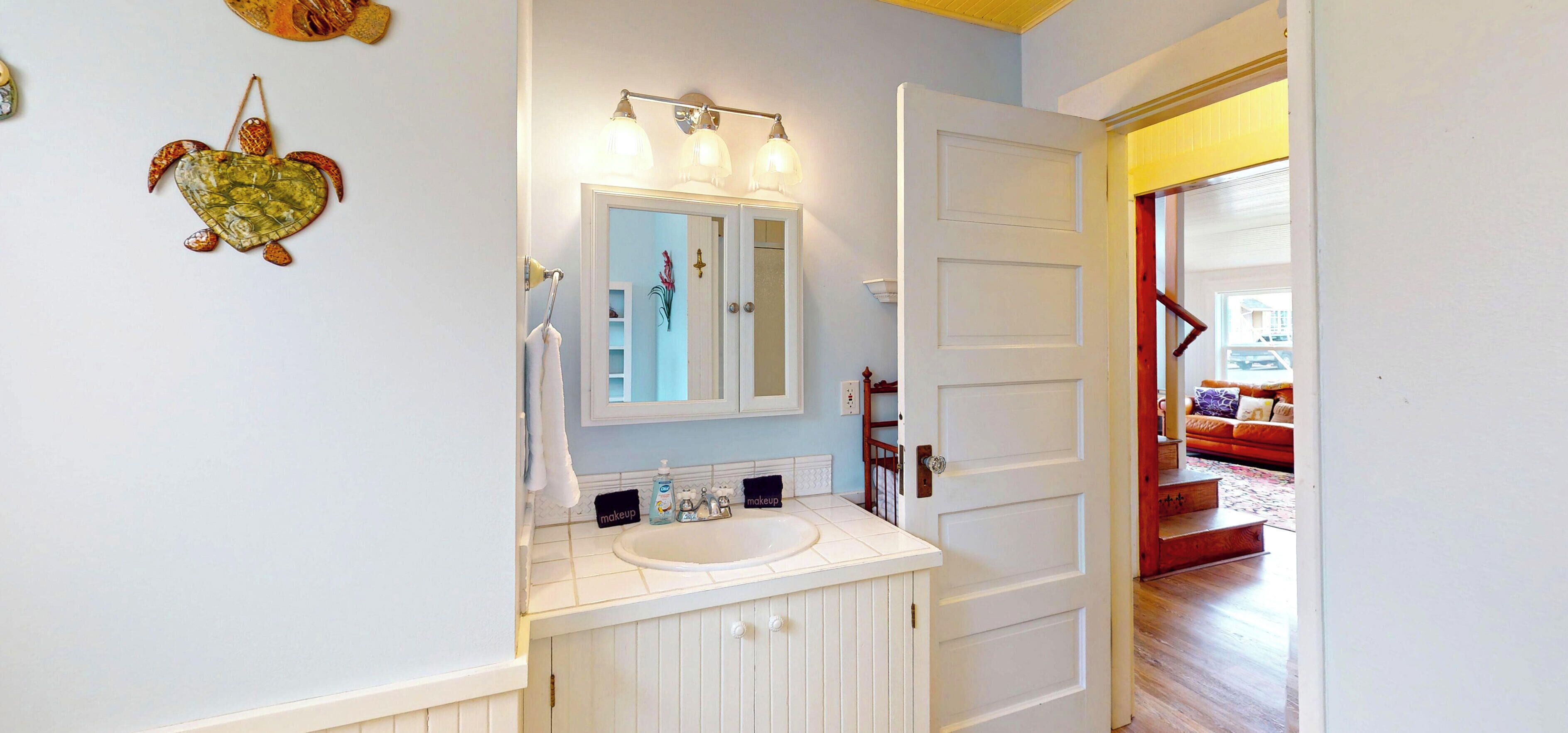 A bathroom with a white sink, a mirror, and a towel rack.