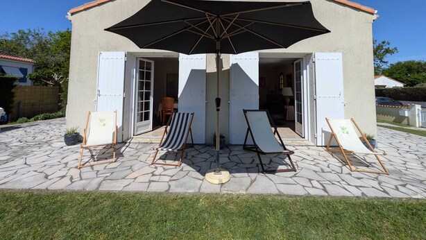 A building with a tiled patio, a large umbrella, and two easels with canvases. - Family home in Parc-Vallière neighborhood, near Royan beach (Royan)
