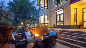 A patio area with wicker furniture, a fire pit, and potted plants. - Alaya Stays Thistle House 4 BHK Hideaway (Bhimtal)