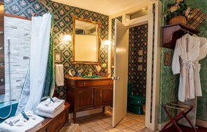 Ein Badezimmer mit einem Holzwaschtisch, einem Spiegel, einer Duschvorhang und einer grünen Toilette.