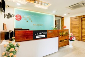 A reception desk with a 'Townhouse' sign, a clock, and a floral arrangement.