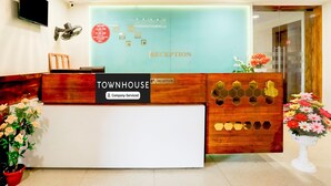 A reception desk with a sign indicating 'Townhouse Company Serviced' and a 'Reception' sign above it. - Super Townhouse Prahladnagar (Ahmedabad)