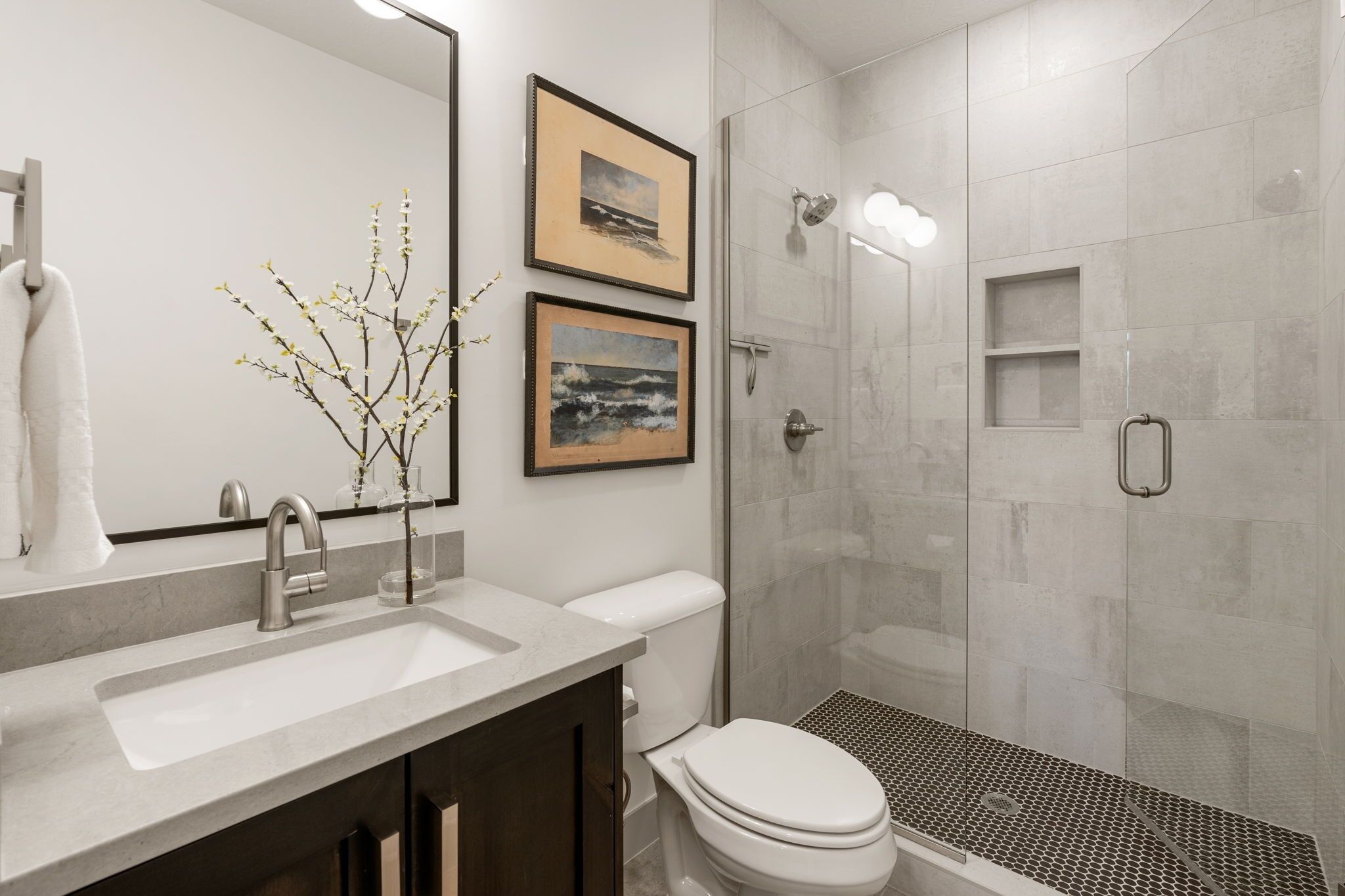 A modern bathroom with a sink, toilet, and shower.