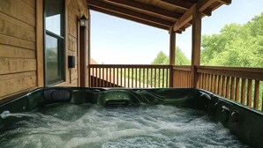 Un jacuzzi en una cabaña de madera con vistas a árboles.