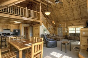 A spacious cabin interior with a dining area, living room, and a loft bedroom. - Mountain Paradise 3 Bedroom Cabin (Sevierville)