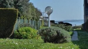 A pathway leading to a building with a large spherical light fixture and a view of the sea. - Sea View House for 9 - Beach Just Around the Corner & Family Comfort (Sarzeau)