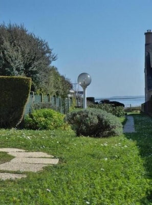 A pathway leading to a building with a large spherical light fixture and a view of the sea. - Sea View House for 9 - Beach Just Around the Corner & Family Comfort (Sarzeau)