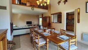 A dining area with a long wooden table set for six, surrounded by six chairs. - Sea View House for 9 - Beach Just Around the Corner & Family Comfort (Sarzeau)