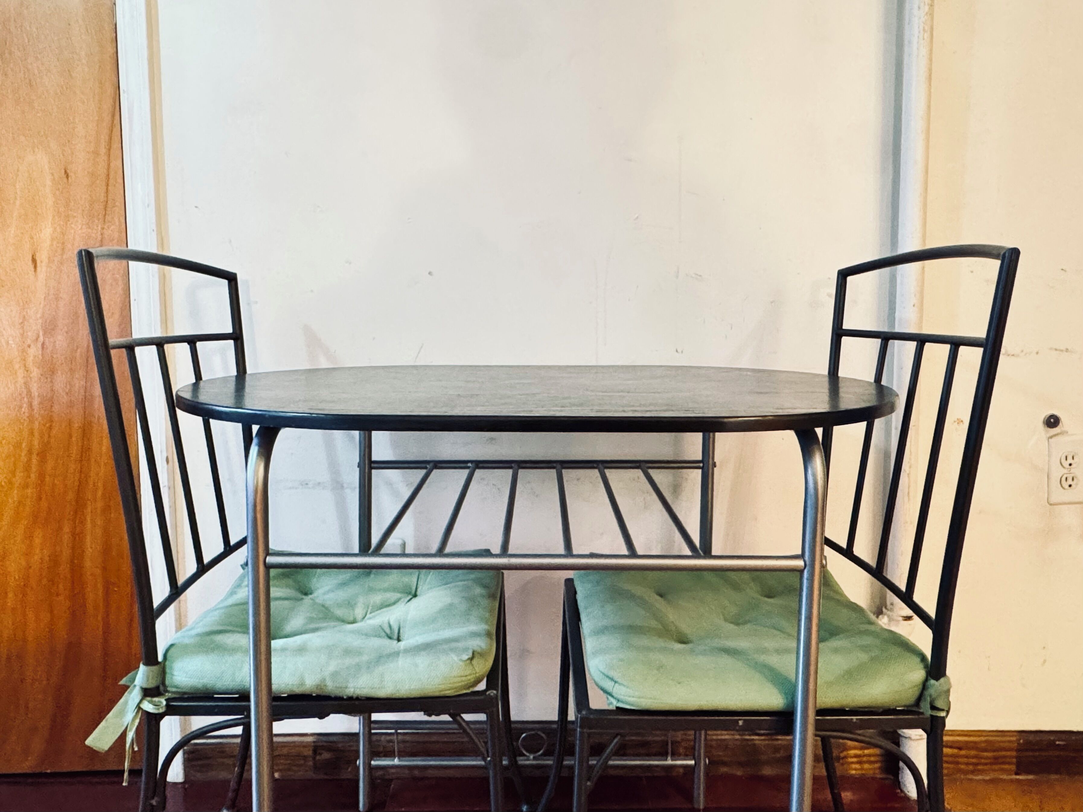 Een eettafel met twee stoelen, elk met een zacht zitkussen.