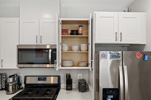 A kitchen with white cabinets, a microwave, a stainless steel refrigerator, a toaster, and a coffee maker. - 2BR 2BA DC Oasis Free Parking Near Capitol Hill (Washington)