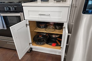 A kitchen with a white cabinet containing pots and pans. - 2BR 2BA DC Oasis Free Parking Near Capitol Hill (Washington)