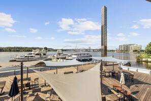 A waterfront property with a dock, outdoor seating, and a view of the river and bridge. - 2BR 2BA DC Oasis Free Parking Near Capitol Hill (Washington)
