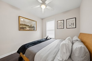 A bedroom with a bed, a ceiling fan, and two framed pictures on the wall. - 2BR 2BA DC Oasis Free Parking Near Capitol Hill (Washington)