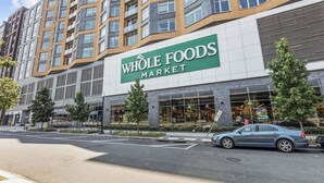 Ein Gebäude von Whole Foods Market mit modernem Design, großen Fenstern und einem Parkplatz davor.