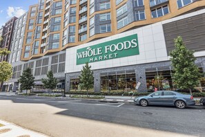 Een Whole Foods Market gebouw met een modern ontwerp, grote ramen en een parkeerplaats ervoor.