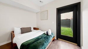 Ein Schlafzimmer mit Bett, Fenster und einer Tür, die nach draußen führt.