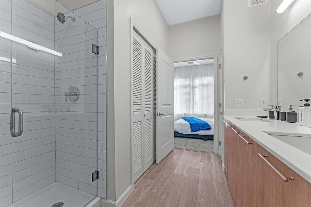 A modern bathroom with a shower, toilet, and sink.