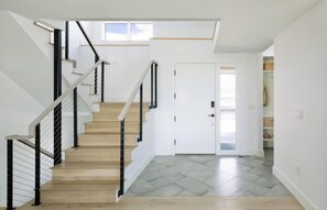 A staircase with wooden steps and black railings, leading to a white door. - Spacious 4-bedroom house in beautiful Boulder (Boulder)