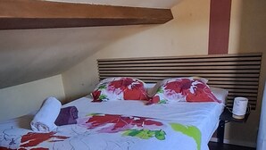 Une chambre à coucher avec un lit, une table de chevet et une fenêtre.