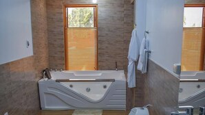 A modern bathroom with a bathtub, toilet, and sink. - CASA TALIOS (Carhuaz)