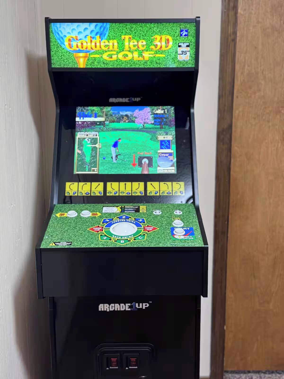 A vintage arcade machine with a golf game titled 'Golden Tee 3D Golf.'