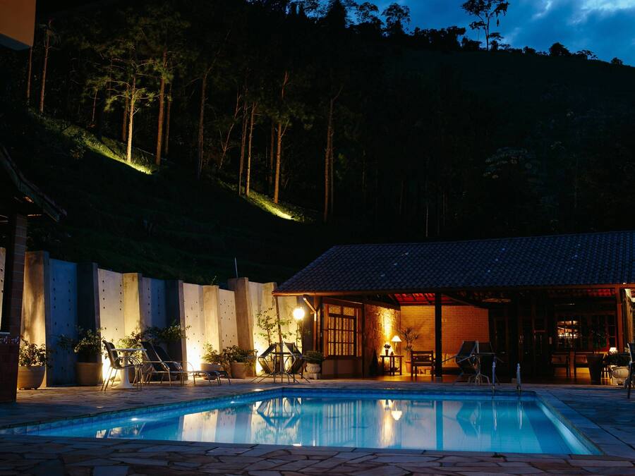 Una piscina al aire libre, sombrillas, sillones reclinables de piscina
