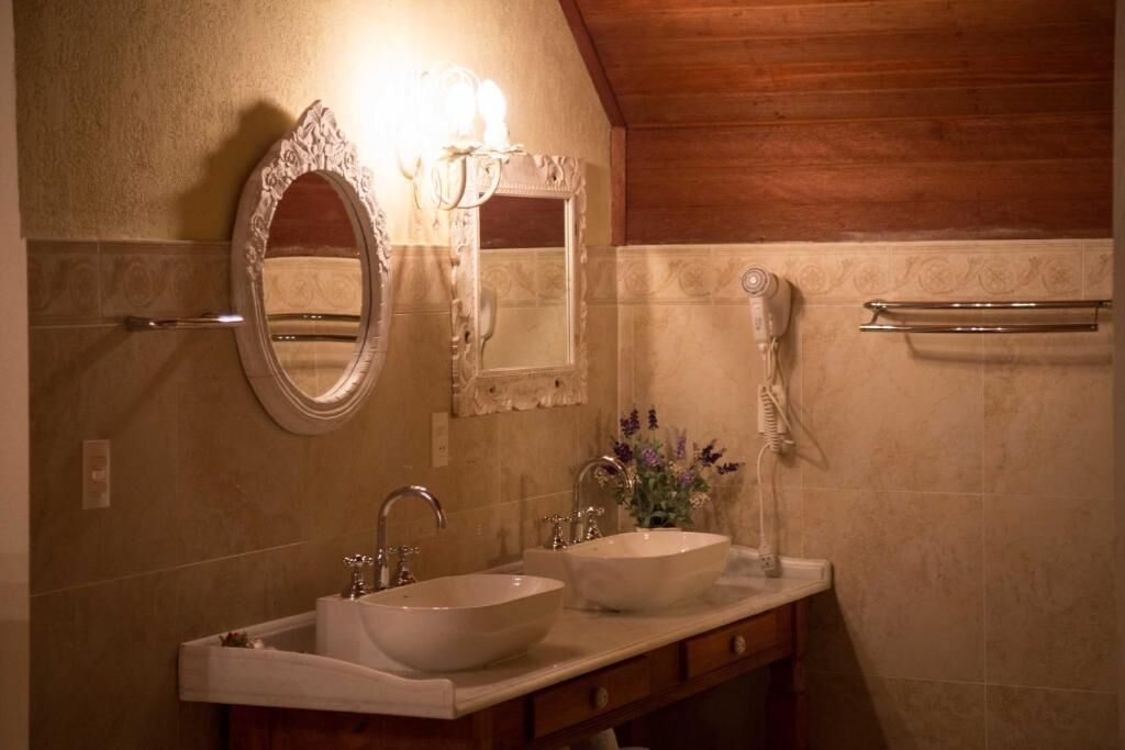 A bathroom with two sinks, a mirror, and a towel rack.