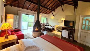 Una habitación amplia con chimenea, televisor y un rincón de descanso acogedor.