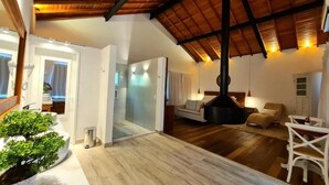 Amplia sala de estar con techo alto, chimenea y zona de estar con sofá y sillones.