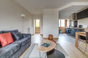 Ein zeitgemäßer Wohnbereich mit Sofa, Couchtisch und Küchenzeile.
