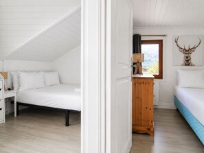 Une chambre à coucher avec un lit, une commode et une fenêtre donnant sur un beau paysage.